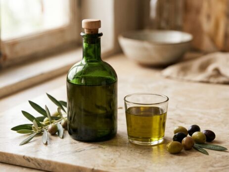 Zeytinyağı şişesi ve bardakta zeytinyağı, yanında zeytin dalı