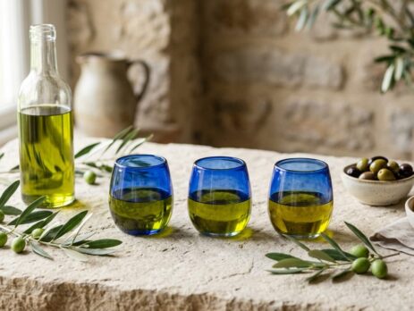 Mavi tadım bardaklarında zeytinyağı, zeytin dalı ve ekmek